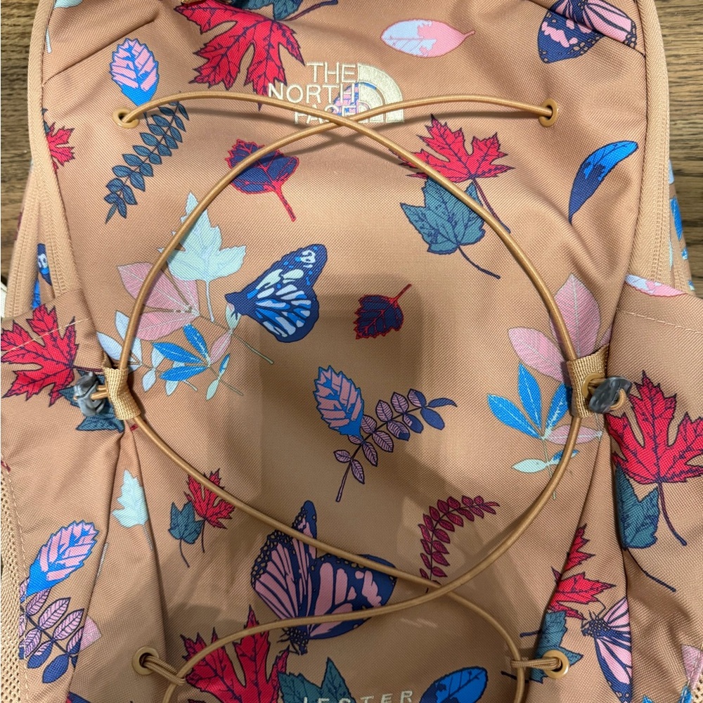 The North Face Tan Computer Backpack with Pink Red and Blue Butterfly Print.
